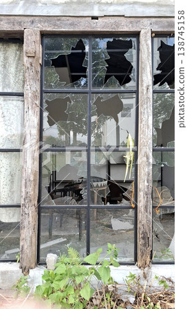 Vibrant Minimalist photo of broken window with green plants in front Vibrant Minimalist photo of broken window with green plants in front 138745158