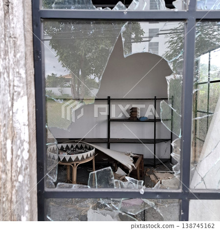 Gritty Minimalist scene of damaged room through shattered window Gritty Minimalist scene of damaged room through shattered window 138745162