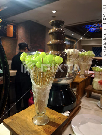 Candid Festive Buffet Scene with Chocolate Fountain and Fruit Skewers Candid Festive Buffet Scene with Chocolate Fountain and Fruit Skewers 138745191