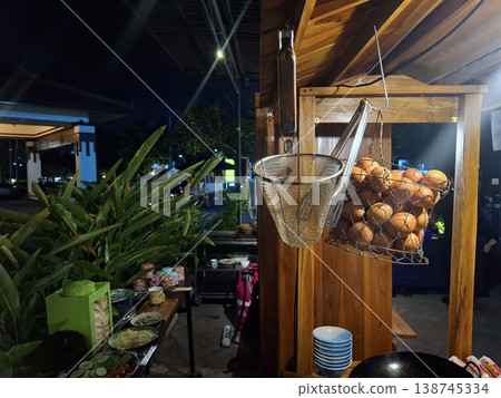 Candid Atmospheric Nighttime Scene of a Street Food Stall with Eggs and Cooking Equipment Candid Atmospheric Nighttime Scene of a Street Food Stall with Eggs and Cooking Equipment 138745334