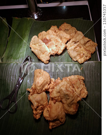 Moody Appetizing View of Golden Fried Fritters on Banana Leaves 138745357