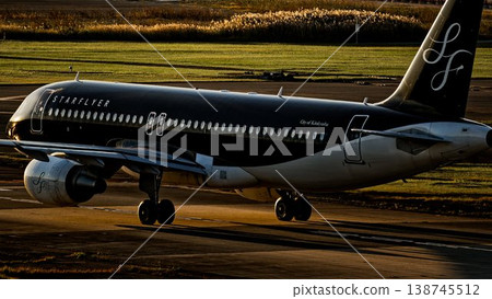 傍晚時分,一架星飛航空的空中巴士A320客機在福岡機場的跑道上滑行。 傍晚時分,一架星飛航空的空中巴士A320客機在福岡機場的跑道上滑行。 138745512