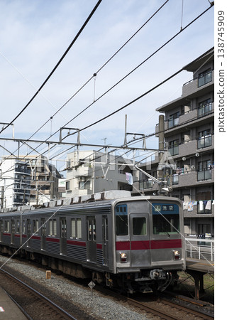 一列火車從公寓大樓旁駛過。 一列火車從公寓大樓旁駛過。 138745909