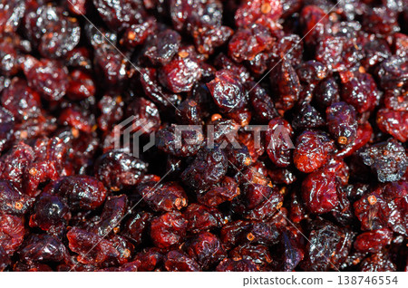 Vibrant and glossy dried cranberries glisten under the sun, showcasing their rich color in a market setting during the harvest season Vibrant and glossy dried cranberries glisten under the sun, showcasing their rich color in a market setting during the harvest season 138746554
