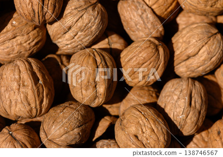 Walnuts nestled in a rustic display showcasing natural textures and earthy tones during a sunlit afternoon harvest Walnuts nestled in a rustic display showcasing natural textures and earthy tones during a sunlit afternoon harvest 138746567
