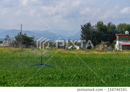 Lush green fields come alive with irrigation under a bright sky in rural landscape Lush green fields come alive with irrigation under a bright sky in rural landscape 138746591