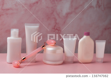 Skincare beauty products set with facial roller, cream jar, serum dropper and cosmetic bottles on pink background, beauty routine concept 138747082