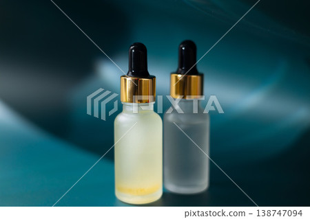 Frosted glass cosmetic dropper bottle on natural stone with dark blue background, skincare serum packaging mockup, minimal beauty product concept 138747094