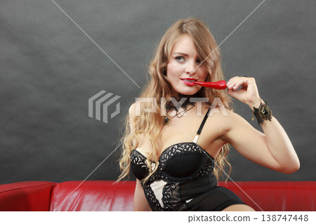 Woman wearing lingerie holding chilli pepper Woman wearing lingerie holding chilli pepper 138747448