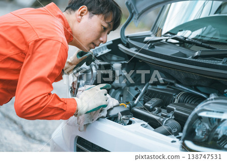 Automotive mechanic inspecting the engine compartment. Automotive mechanic inspecting the engine compartment. 138747531