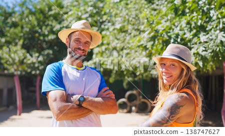 Smiling couple wearing hats standing outdoors in summer sunshine 138747627