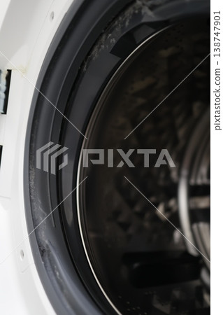 Close-up of dust and dirt attached to the lid and rubber parts of a drum-type washing machine. Close-up of dust and dirt attached to the lid and rubber parts of a drum-type washing machine. 138747901