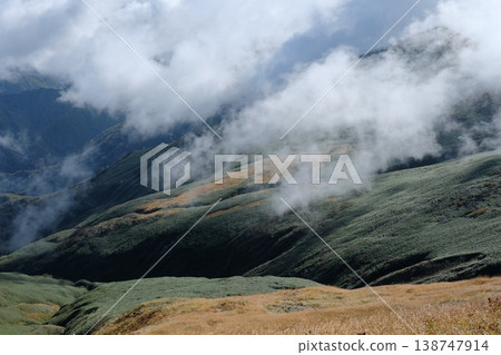 Autumn scenery of bamboo grass fields and mountainsides covered in crimson grass, with clouds drifting across them and valleys carved into the landscape. Autumn scenery of bamboo grass fields and mountainsides covered in crimson grass, with clouds drifting across them and valleys carved into the landscape. 138747914