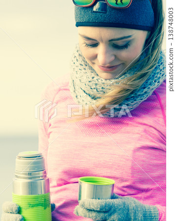 Fit woman in cold day warming up drink tea 138748003