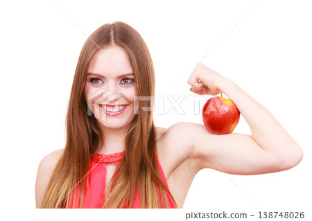 Woman fit girl holds apple fruit on her biceps arm Woman fit girl holds apple fruit on her biceps arm 138748026
