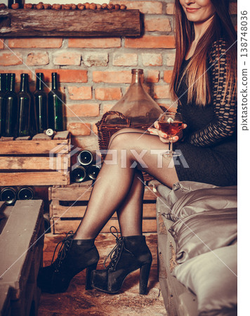 Woman tasting wine in rural cottage interior Woman tasting wine in rural cottage interior 138748036