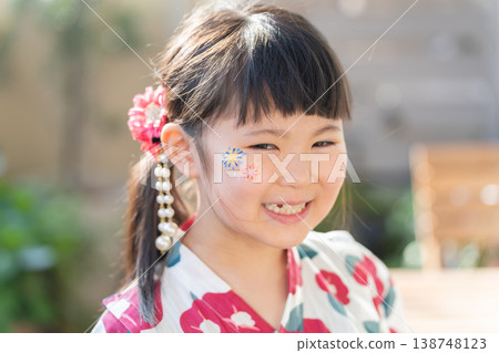 一個穿著浴衣、臉上塗著彩繪的女孩 138748123