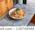 Thai style seafood spaghetti with shrimp clams and fresh herbs on white plate rustic stone background 138748948