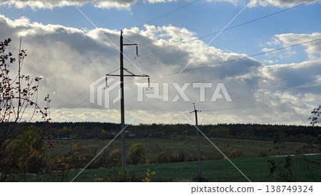 Electric power lines poles field landscape sky transmission lines rural infrastructure closeup Electric power lines poles field landscape sky transmission lines rural infrastructure closeup 138749324