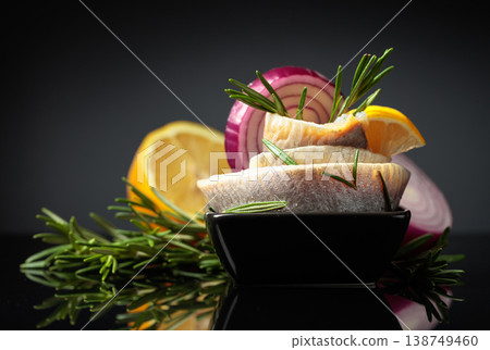 Herring fillet with lemon, red onion, and rosemary. 138749460
