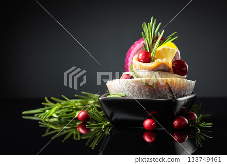 Herring fillet in oil with lemon, onion, rosemary, and cranberries. 138749461