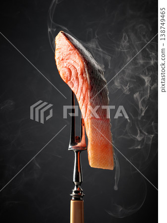 Smocked salmon fillet with natural smoke on a black background. 138749465