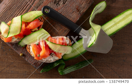 Sandwiches with smoked trout, cream cheese, fresh cucumber, and capers on a wooden table. Sandwiches with smoked trout, cream cheese, fresh cucumber, and capers on a wooden table. 138749470