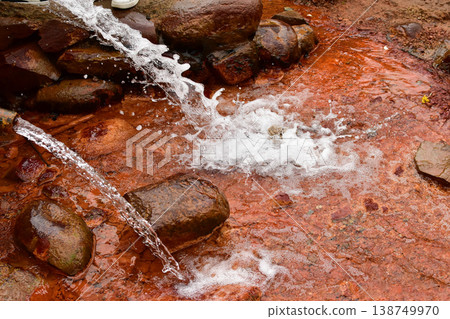 Clear water flows down rocks, creating white spray 138749970