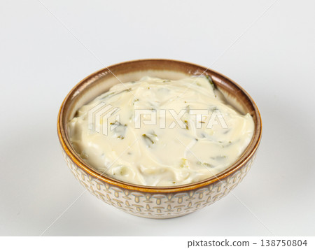 Creamy tartar sauce with herbs and pickles in a patterned ceramic bowl isolated on white Creamy tartar sauce with herbs and pickles in a patterned ceramic bowl isolated on white 138750804