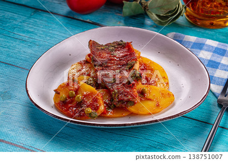 Baked fish fillet with tomato sauce and vegetables on a rustic blue wooden table 138751007