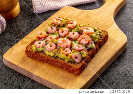 Shrimp and avocado toast on a wooden board with garlic, lime, and chili pepper Shrimp and avocado toast on a wooden board with garlic, lime, and chili pepper 138751039