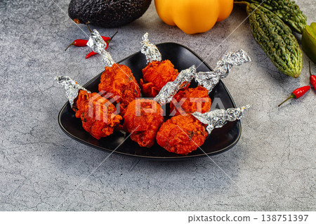 Spicy Indian Chicken Lollipops appetizer in a bowl with fresh vegetables Spicy Indian Chicken Lollipops appetizer in a bowl with fresh vegetables 138751397