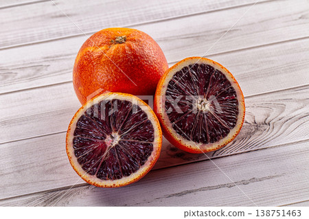 Whole and halved fresh blood oranges on a white wooden background Whole and halved fresh blood oranges on a white wooden background 138751463