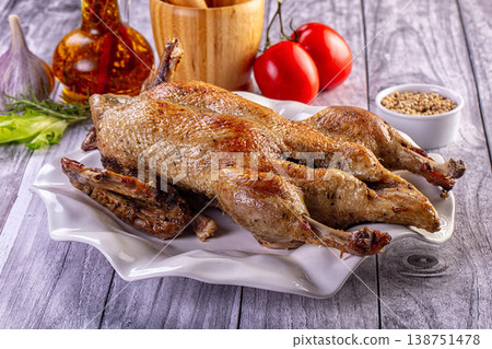 Gourmet roasted ducks with crispy skin served on a platter with fresh tomatoes and herbs Gourmet roasted ducks with crispy skin served on a platter with fresh tomatoes and herbs 138751478
