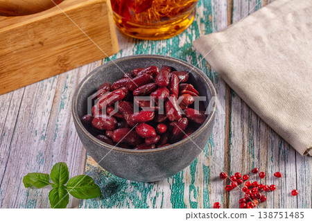 Red kidney beans in a grey bowl with fresh basil and peppercorns on a rustic wooden background Red kidney beans in a grey bowl with fresh basil and peppercorns on a rustic wooden background 138751485
