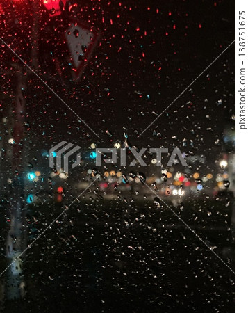 Raindrops on a car windshield at night with blurred city lights outside, capturing rainy urban ambiance, reflections, and moody nighttime atmosphere. Raindrops on a car windshield at night with blurred city lights outside, capturing rainy urban ambiance, reflections, and moody nighttime atmosphere. 138751675