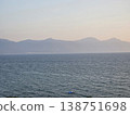 Picturesque view to blue sea and mountain island on horizon in mist. Calm water surface, background for traveling and vacation,Beautiful sea view, sailboats far away in the sea in sunny day. 138751698