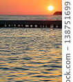 people enjoying sunset at the beach golden sunset illuminates the coastal sea waves and rugged rocks in Kusadasi, Turkey, creating a warm and serene atmosphere against the backdrop of the Aegean Sea 138751699