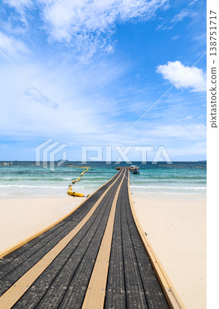 A beach and floating pier under a clear blue sky 138751717