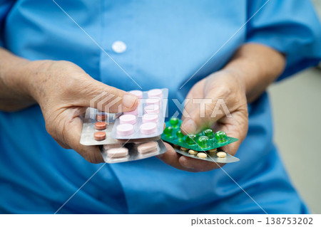 Asian elderly woman holding pill drug in hand, strong healthy medical concept. Asian elderly woman holding pill drug in hand, strong healthy medical concept. 138753202