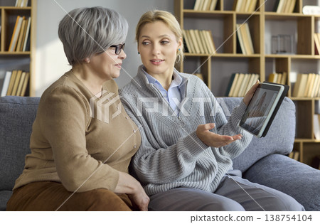 Senior woman and daughter video call doctor on tablet for home telemedicine care Senior woman and daughter video call doctor on tablet for home telemedicine care 138754104