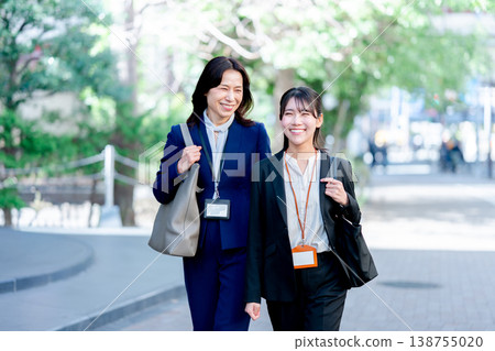 Two businesswomen walking together Two businesswomen walking together 138755020