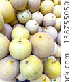 Fresh melons stacked together in a vibrant display at a market, showcasing their textured skin and round shapes 138755050
