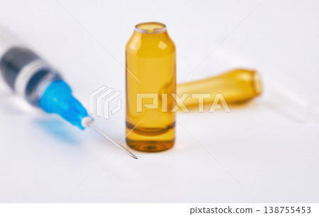 Selective focus on an open amber vial with a medical needle and syringe blurred behind Selective focus on an open amber vial with a medical needle and syringe blurred behind 138755453