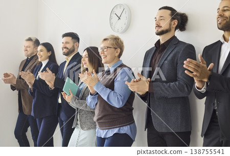 Diverse business team standing and applauding in office, celebrating success Diverse business team standing and applauding in office, celebrating success 138755541