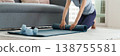 Asian adult woman roll yoga mat home living room floor with dumbbells wellness fitness workout activity body health lifestyle indoor training self care routine 138755581