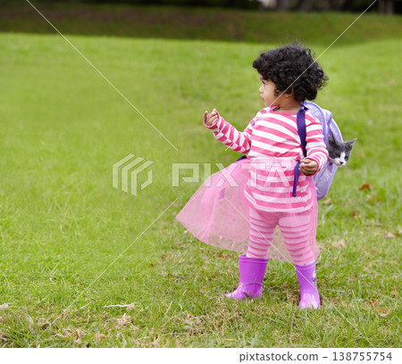 Nature, kitten and girl child with backpack walking on grass in outdoor garden in summer. Confused, backyard and young kid with childhood playing on the lawn with cat in field or park in countryside. Nature, kitten and girl child with backpack walking on grass in outdoor garden in summer. Confused, backyard and young kid with childhood playing on the lawn with cat in field or park in countryside. 138755754