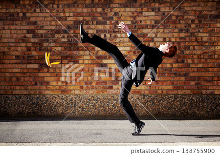 Accident, slip and banana peel with a business man in the city, falling by mistake on a street. Walking, step and unlucky with a young professional employee in an urban town for his commute to work Accident, slip and banana peel with a business man in the city, falling by mistake on a street. Walking, step and unlucky with a young professional employee in an urban town for his commute to work 138755900