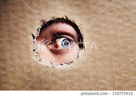 Closeup, cardboard and eye spy on hole, peek and search on mockup space. Face, macro and man peeping through paper board for secret, security and watch for surveillance, discover mystery and privacy Closeup, cardboard and eye spy on hole, peek and search on mockup space. Face, macro and man peeping through paper board for secret, security and watch for surveillance, discover mystery and privacy 138755918