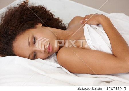Woman, depressed and lying on bed with worry, naked and sheet in room for mental health, stress management or anxiety. Brazilian person, nude and cover for skin, vulnerability or shield for mindset Woman, depressed and lying on bed with worry, naked and sheet in room for mental health, stress management or anxiety. Brazilian person, nude and cover for skin, vulnerability or shield for mindset 138755945